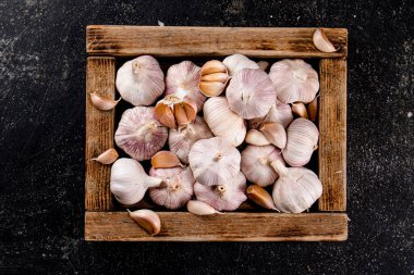 Fresh garlic on a wooden tray. On a black background. High quality photo