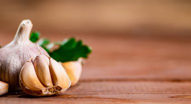 Cloves of fresh garlic with parsley. On a wooden background. High quality photo