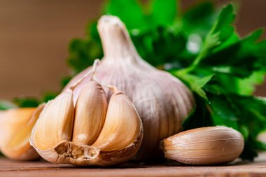 Cloves of fresh garlic with parsley. On a wooden background. High quality photo