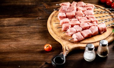Pork kebab raw on skewers on a cutting board. On a wooden background. High quality photo