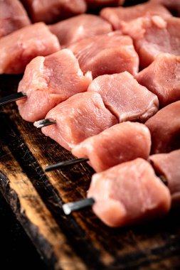 Pork kebab raw on skewers on a cutting board. High quality photo