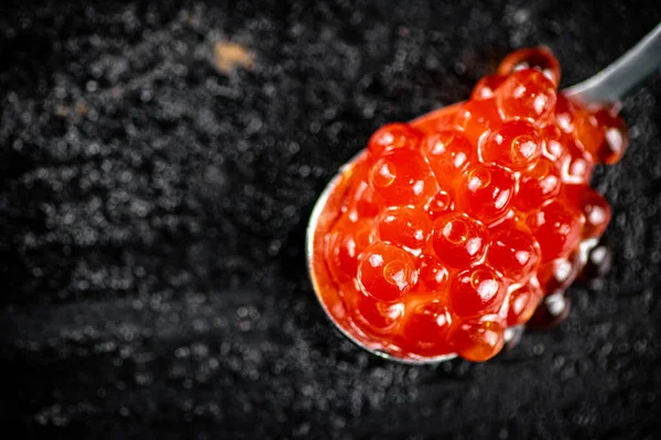 Κόκκινο Χαβιάρι Κουτάλι Στο Τραπέζι Μαύρο Φόντο Υψηλής Ποιότητας Φωτογραφία — Φωτογραφία Αρχείου