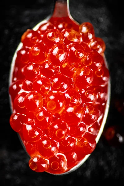 Κόκκινο Χαβιάρι Κουτάλι Στο Τραπέζι Μαύρο Φόντο Υψηλής Ποιότητας Φωτογραφία — Φωτογραφία Αρχείου