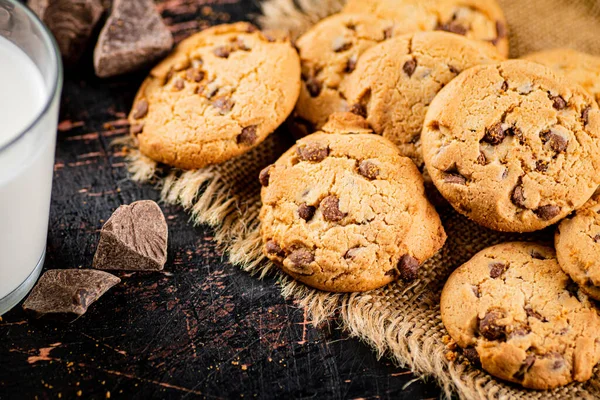 stock image Pile of homemade cookies with pieces of milk chocolate on the table. On a wooden background. High quality photo. 