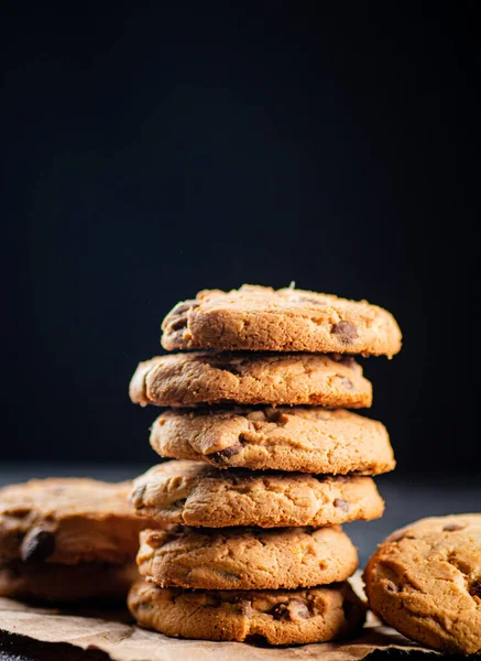 A pile of milk chocolate cookies. On a black background. High quality photo