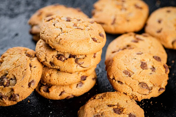 A pile of milk chocolate cookies. On a black background. High quality photo