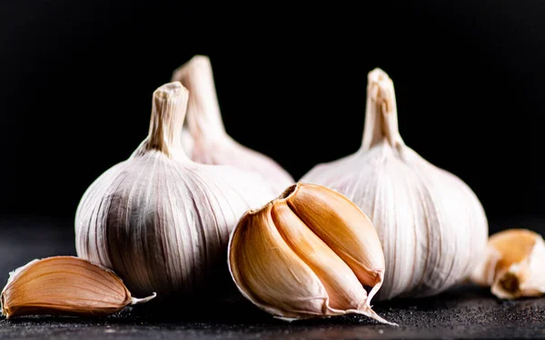 Fresh garlic on the table. On a black background. High quality photo