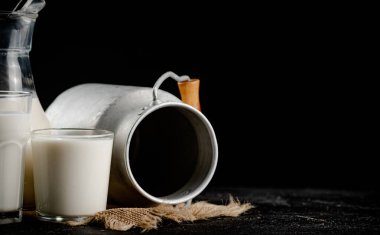 Fresh homemade milk on the table in a glass. On a black background. High quality photo