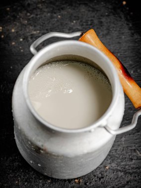 Fresh milk in a can on the table. On a black background. High quality photo