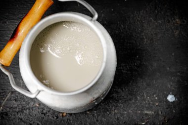 Fresh milk in a can on the table. On a black background. High quality photo