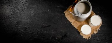 Fresh milk in a can on the table. On a black background. High quality photo