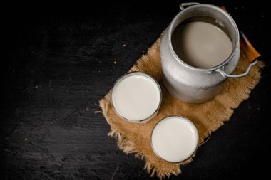 Fresh milk in a can on the table. On a black background. High quality photo