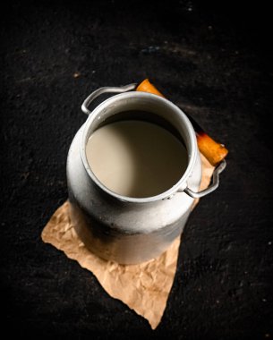 Fresh milk in a can on the table. On a black background. High quality photo