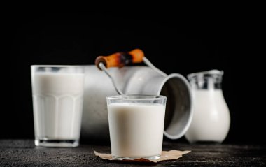 Fresh country milk in a glass on the table. On a black background. High quality photo