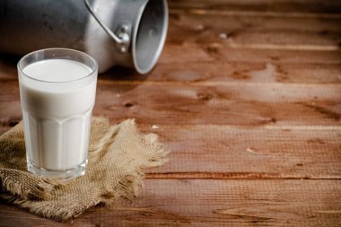 A glass of homemade village milk. On a wooden background. High quality photo