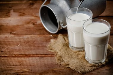 A glass of homemade village milk. On a wooden background. High quality photo
