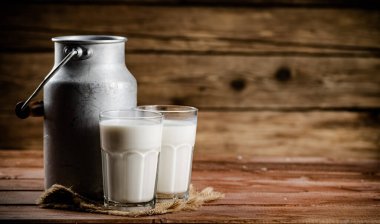 A glass of homemade village milk. On a wooden background. High quality photo