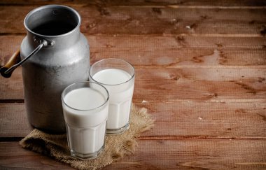 A glass of homemade village milk. On a wooden background. High quality photo