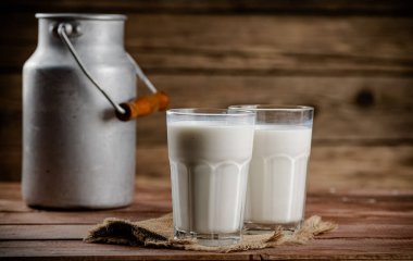 A glass of homemade village milk. On a wooden background. High quality photo