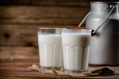 A glass of homemade village milk. On a wooden background. High quality photo