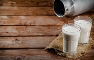 A glass of homemade village milk. On a wooden background. High quality photo