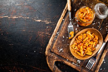 Marinated mushrooms on a cutting board. Against a dark background. High quality photo