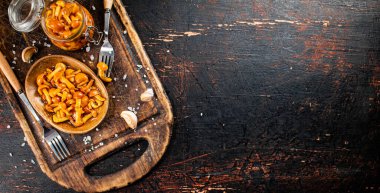 Marinated mushrooms on a cutting board. Against a dark background. High quality photo