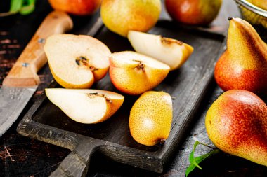 Sliced fresh pear on a cutting board. Against a dark background. High quality photo