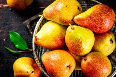Ripe pears in a colander. On a rustic dark background. High quality photo