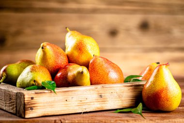 Fresh pears on a tray with leaves. On a wooden background. High quality photo