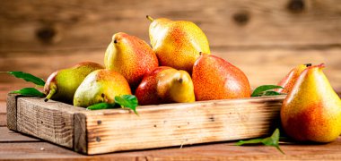 Fresh pears on a tray with leaves. On a wooden background. High quality photo