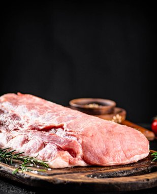 Raw pork on a cutting board. On a black background. High quality photo