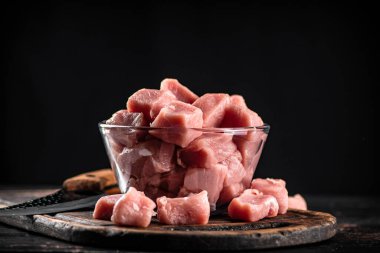 Raw pork in a glass bowl. On a black background. High quality photo