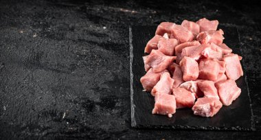 Sliced raw pork on a stone board. On a black background. High quality photo