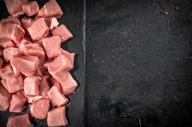 Sliced raw pork on a stone board. On a black background. High quality photo