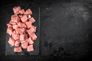 Sliced raw pork on a stone board. On a black background. High quality photo