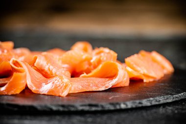 Slices of salted salmon on the table. On a wooden background. High quality photo