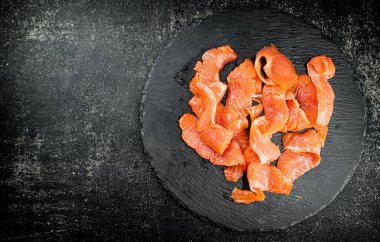 Salted salmon on a stone board. On a black background. High quality photo
