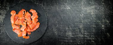 Salted salmon on a stone board. On a black background. High quality photo