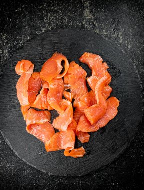 Salted salmon on a stone board. On a black background. High quality photo