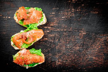 Sandwich with salmon and herbs. Against a dark background. High quality photo