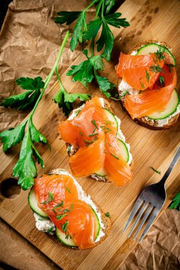 Salmon sandwich on a wooden cutting board. Macro background. High quality photo