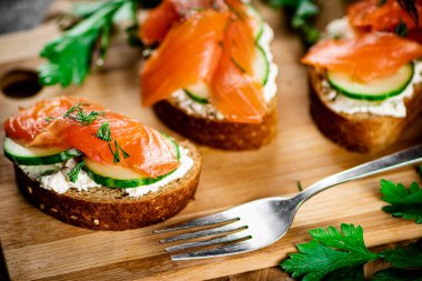 Salmon sandwich on a wooden cutting board. Macro background. High quality photo