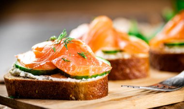 Salmon sandwich on a wooden cutting board. Macro background. High quality photo