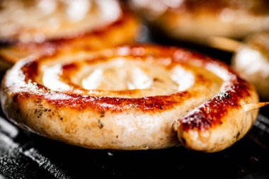 Grilled sausages in a frying pan. On a black background. High quality photo