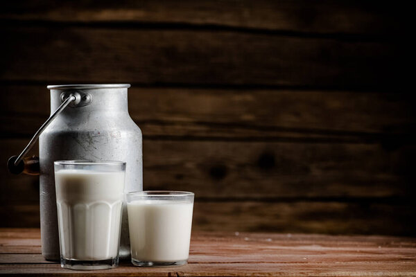 A glass of homemade village milk. On a wooden background. High quality photo