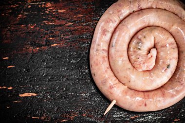 Raw sausage for frying on the table. Against a dark background. High quality photo