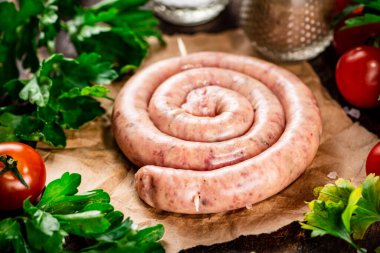 Round raw sausage on paper. High quality photo