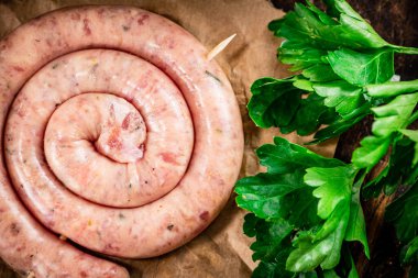 Round raw sausage on paper. High quality photo