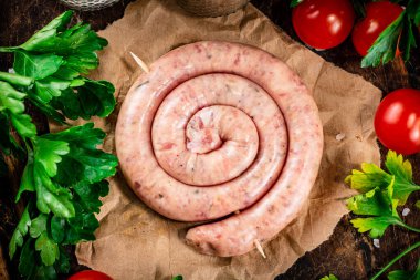 Round raw sausage on paper. High quality photo